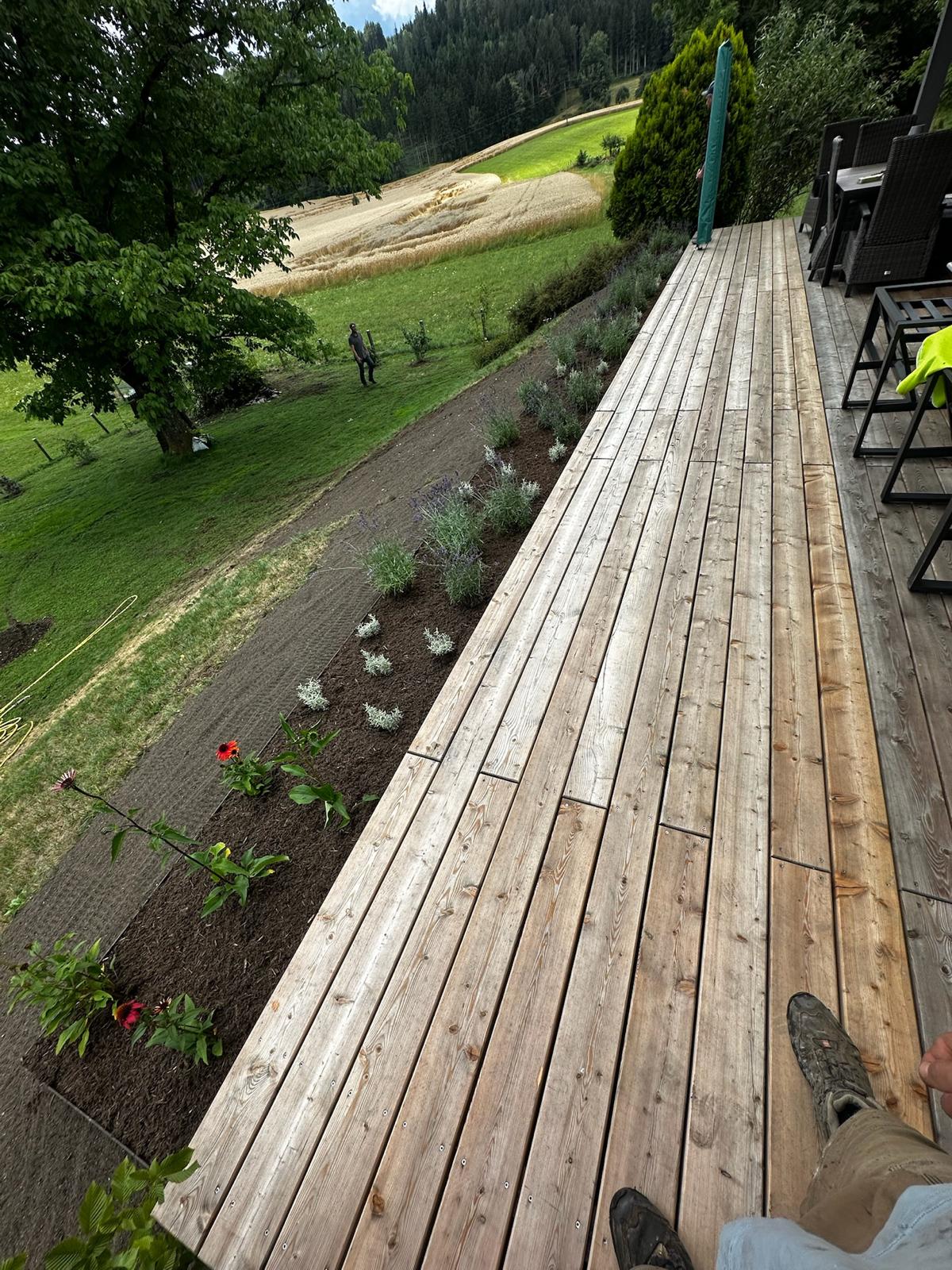 Neu angelegte Pflanzfläche entlang einer Holzterrasse